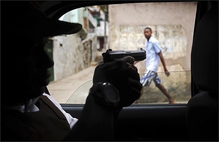 Cảnh sát dùng súng để quan sát các đối tượng khả nghi từ trong xe tuần tra