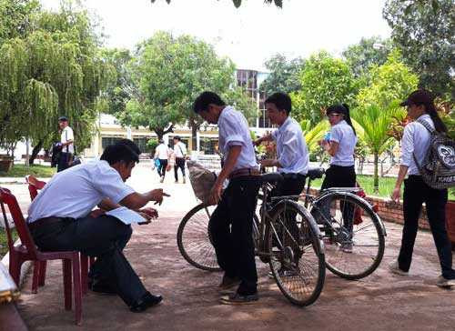 Thầy quản sinh kiểm tra đồng phục học sinh trước khi vào lớp học