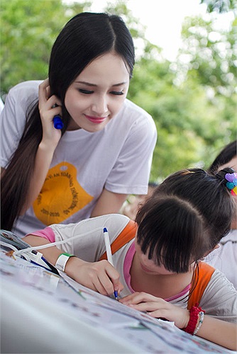 Hoa hậu chơi đùa với các em nhỏ.