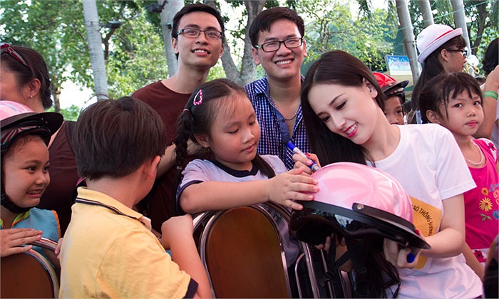 Hoa hậu ký tặng các em nhỏ trên mũ.