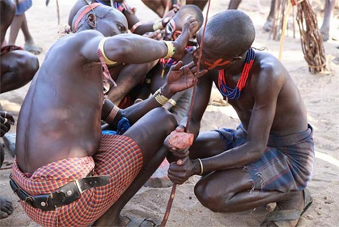 Những chàng trai đang được người lớn giúp vẽ mặt để chuẩn bị thực hiện nghi thức chứng tỏ sự trưởng thành cả về thể chất lẫn tinh thần của mình.