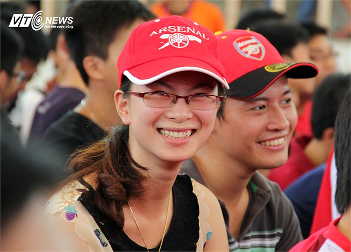 Một nữ fan rạng ngời với chiếc mũ có logo Pháo thủ.