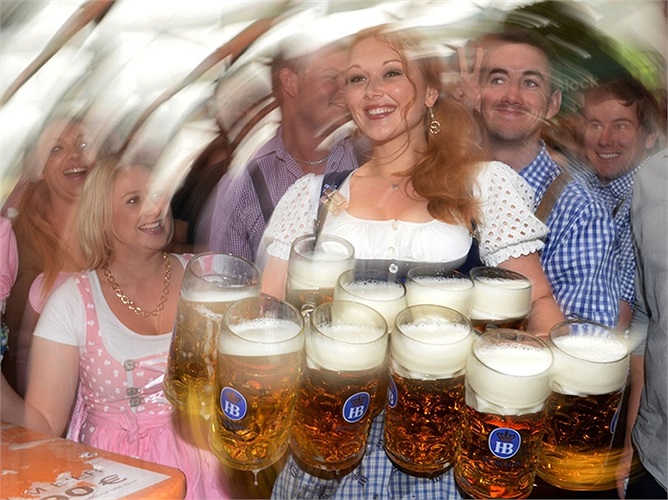 Cô phục vụ xinh đẹp mang bia cho du khách tại lễ hội bia Oktoberfest