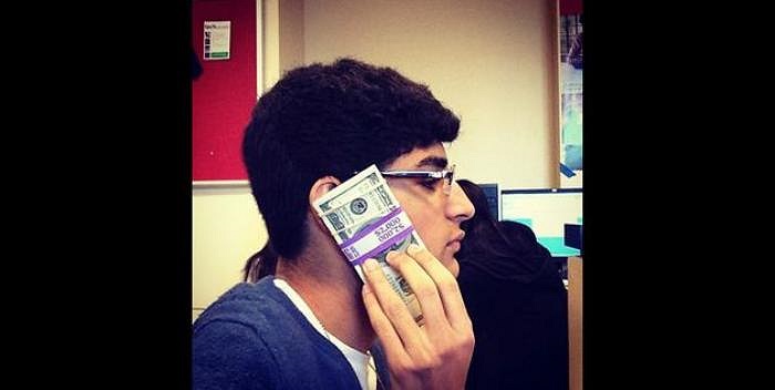 Ảnh chụp Param cầm trên tay một xấp tiền USD áp vào tai