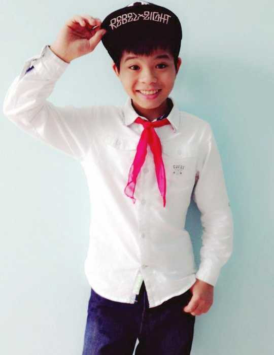 Quang Anh trong trang phục học sinh, đeo khăn quảng đỏ trước khi tới lớp.