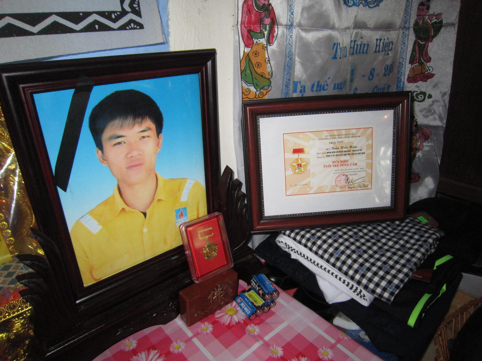 Những bộ quần áo mới, bằng khen, huy hiệu được đặt trang trọng trên bàn thờ anh Trần Hữu Hiệp.