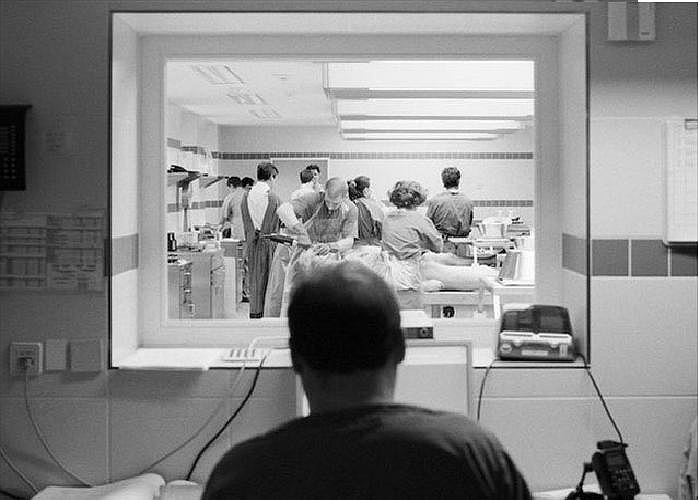 Một người đàn ông quan sát bên ngoài phòng khám nghiệm.