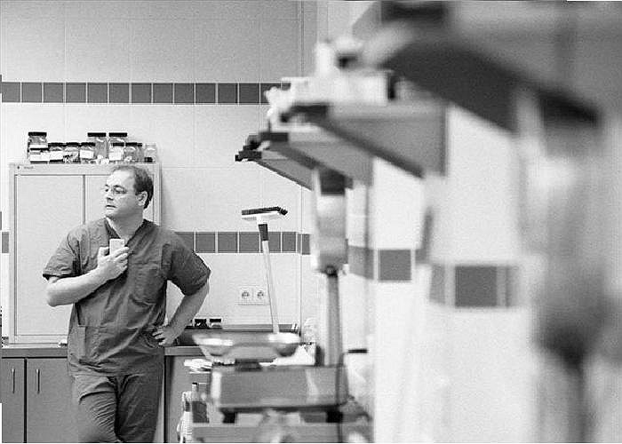 Chuyên viên pháp y đứng nghỉ giữa ca phẫu thuật khám nghiệm.