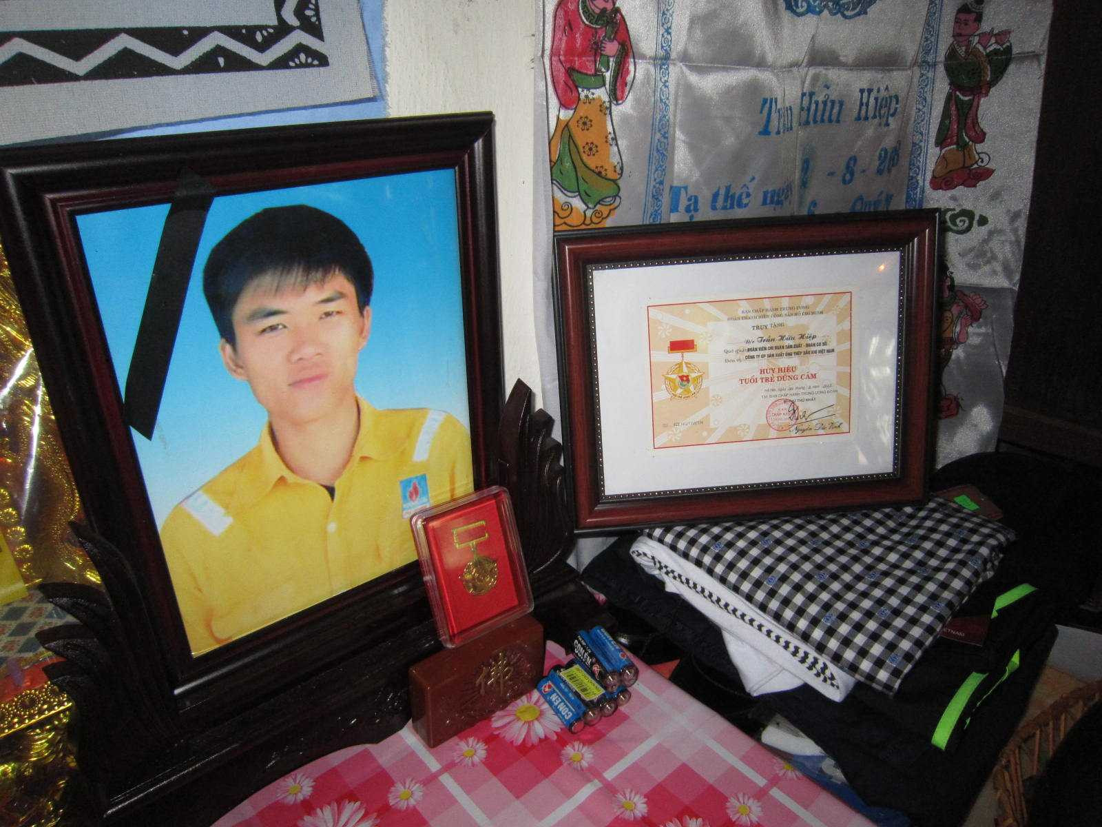 Những bằng khen, huy hiệu của các ngành, các cấp được đặt trang trọng bên di ảnh anh Trần Hữu Trọng.