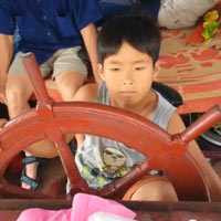 Bùi Minh Hiếu, 10 tuổi điều khiển chiếc tàu chở khách du lịch của gia đình khắp hồ Thung Nai.