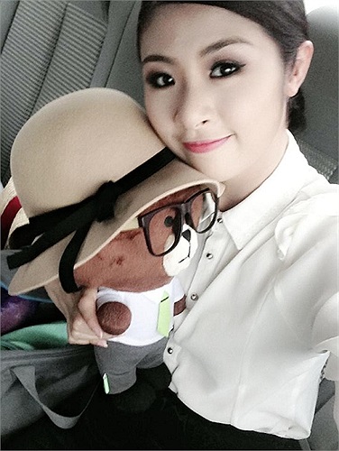 Ngọc Hân trên đường ra máy bay, tranh thủ làm điệu với chú thú bông đáng yêu.