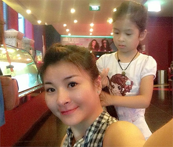 Hai mẹ con làm điệu cho nhau trong lúc chờ phim chiếu.