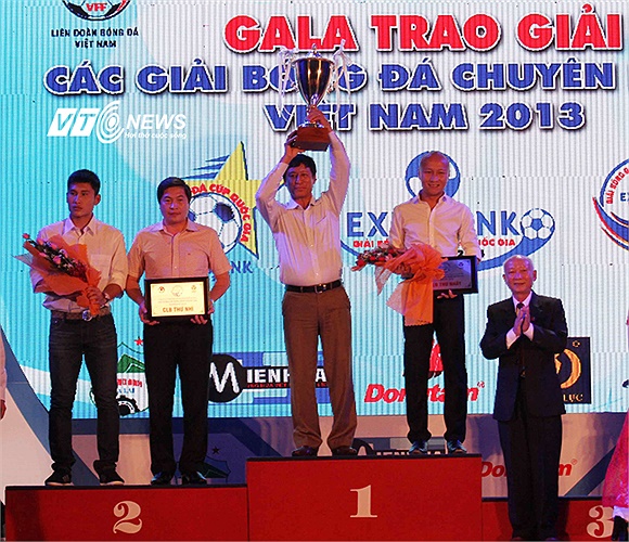 HLV Nguyễn Quang Bảo và trung vệ Cao Xuân Thắng của QNK Quảng Nam nhận danh hiệu vô địch Hạng Nhất.