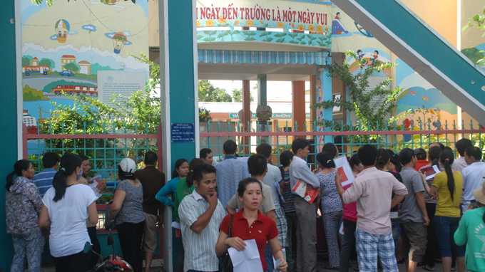 Rất đông phụ huynh tập trung suốt đêm để kiếm một chỗ cho con vào Trường mầm non Hướng Dương - Ảnh: Hữu Khá