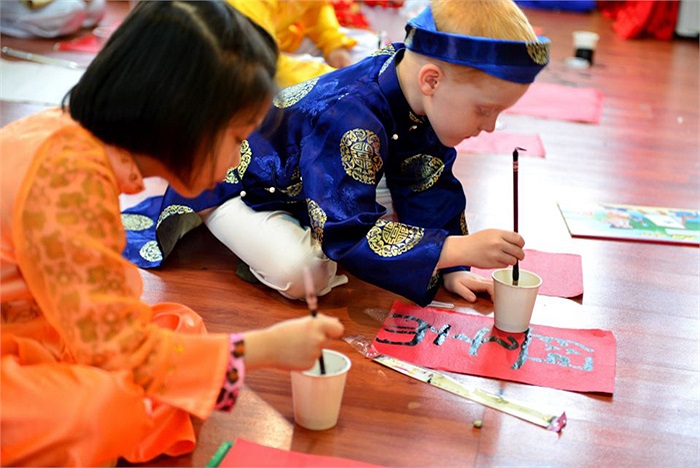 Hình ảnh cậu bé Bodi Ron, 6 tuổi người Úc trong trang phục áo the khăn xếp cầm bút lông viết những nét chữ đầu năm hết sức ngộ nghĩnh khiến mọi người đều cảm thấy thích thú ngắm nhìn