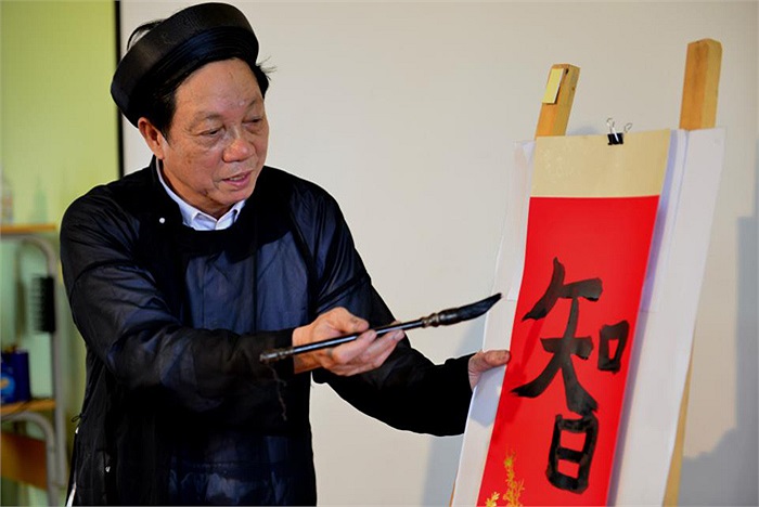 Thầy đồ hướng dẫn từng động tác viết chữ cho các em nhỏ