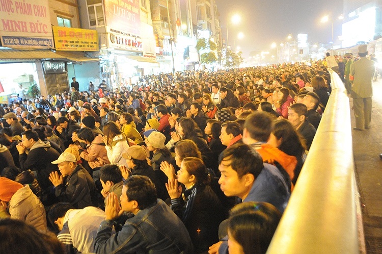 Từ 16h chiều, mọi người đem theo ghế con, giấy báo trải ra kín đường để ngồi giữ chỗ...