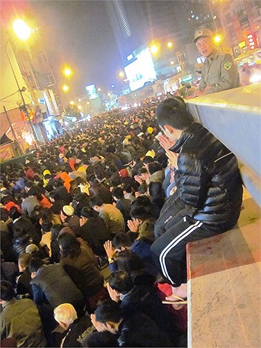 Một thanh niên ngồi vẳt vẻo trên thành cầu vượt, bỏ qua sự nguy hiểm để cầu an, giải hạn...