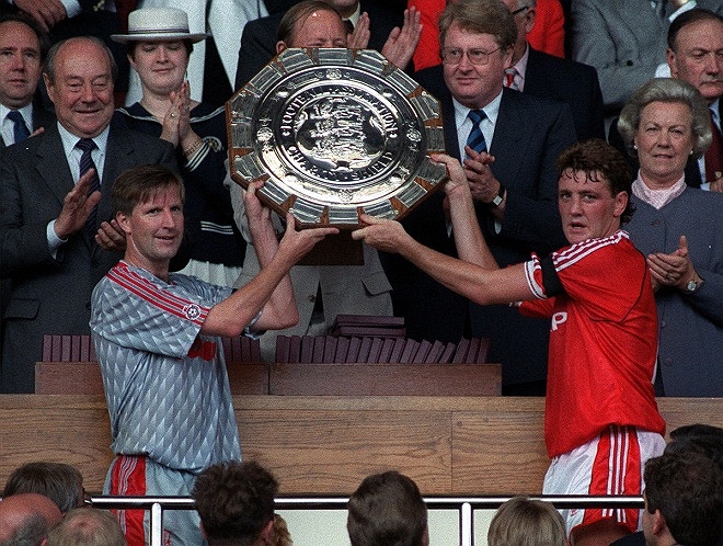 Ronnie Whelan và Steve Bruce chụp ảnh bên cạnh danh hiệu Charity Shield năm 1990.