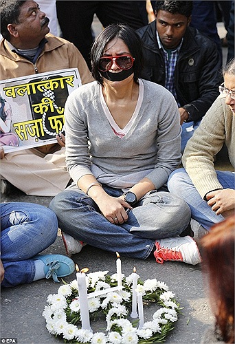 Một người phụ nữ bịt miệng tưởng niệm nạn nhân xấu số