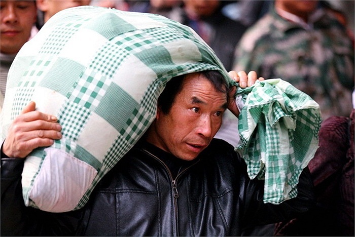 Người lao động xa quê bê tải đồ đạc ra ga