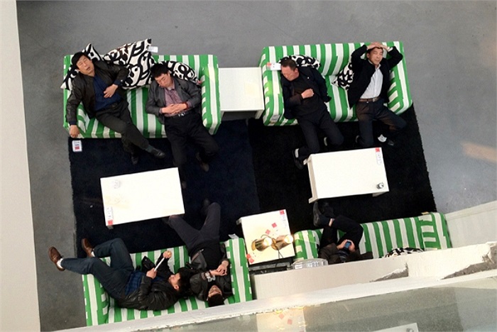 Một số người mặc comple vô tư nằm nghỉ ngơi tại bộ bàn ghế của IKEA.