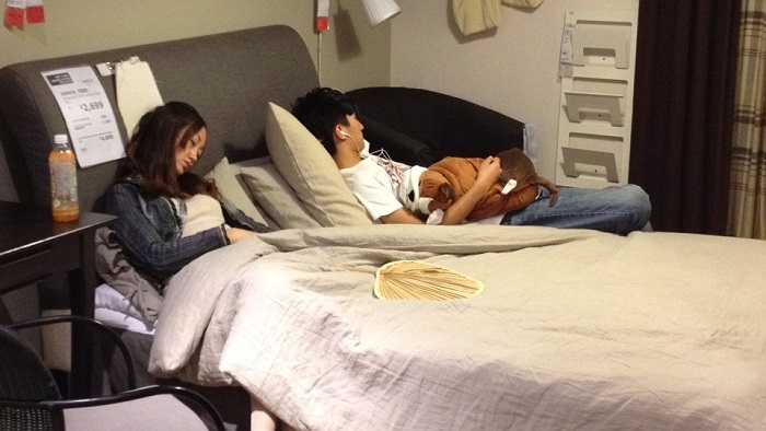 Trong khi một bạn nữ ngủ ngon trên chiếc giường trải nệm êm, một nam thanh niên gần đó đang mải mê nghe nhạc vô cùng thoải mái 