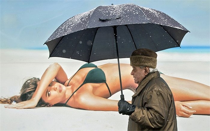 Cụ ông cầm ô đi trong tuyết 'mặc kệ' người mẫu nóng bỏng mặc bikini trong tấm biển quảng cáo trên phố