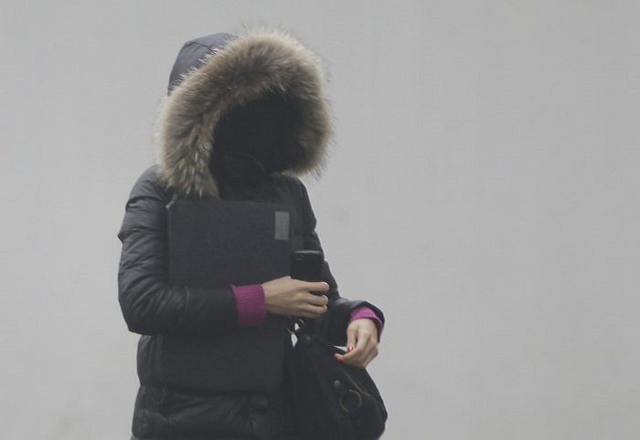 Thiếu nữ trong bộ trang phục kín mít để đối phó với bụi ở Bắc Kinh, Trung Quốc