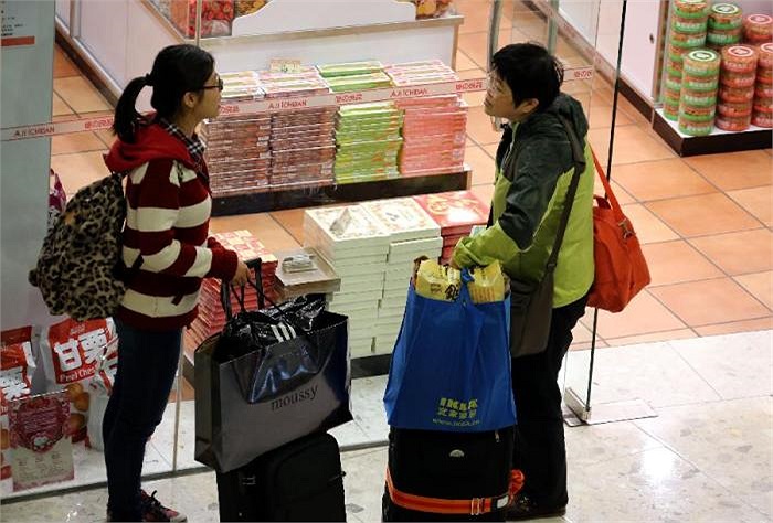 Hai cô gái với tay xách túi hàng nhiều sản phẩm khuyến mại 