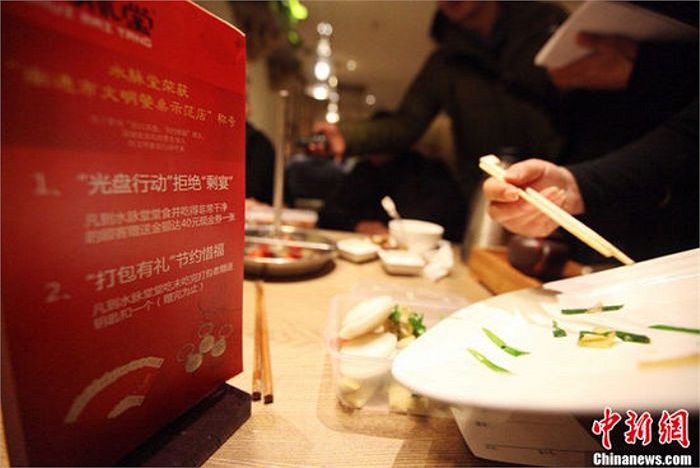 Nhân viên nhà hàng cho đồ ăn vào các hộp để đóng gói 