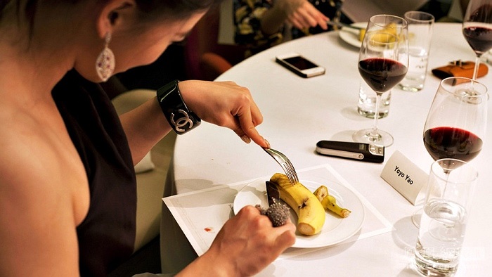 Một học viên đang dùng dao và nĩa để bóc vỏ chuối một cách nhẹ nhàng 