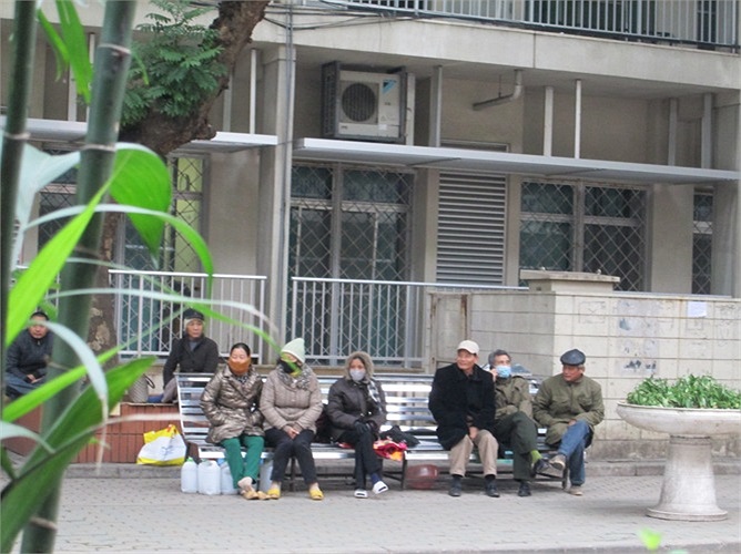 Trước cửa cổng số 4 (bệnh viện Bạch Mai) người già cũng phải ngồi hàng giờ dưới trời rét khi chưa đến giờ thăm bệnh nhân.