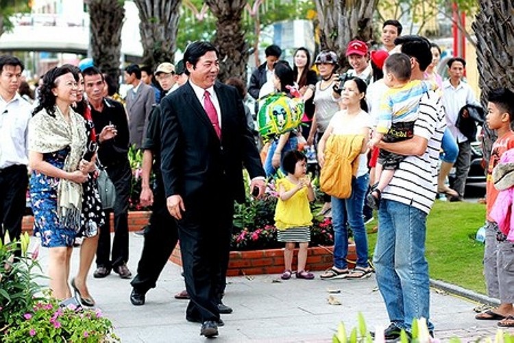 Trên con đường hoa, ông Nguyễn Bá Thanh và người dân cùng bắt tay, trò chuyện. Ảnh: Dân trí