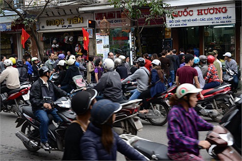 8h sáng, hàng chục người xếp thành hàng dài trên phố Hàng Bông để đợi mua bánh chưng, giò.(Ảnh VNE)