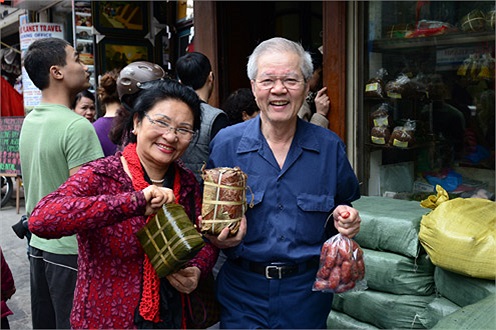 Đến sớm nên sau 20 phút xếp hàng, vợ chồng ông Lập (Việt kiều về quê ăn Tết) cũng đã mua được bánh chưng, giò lụa. Cảnh mua bán này mang lại cho ông bà như trở lại thời bao cấp ngày xưa.(Ảnh VNE)