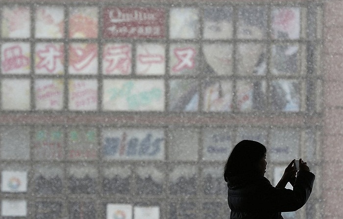 Người phụ nữ đang chụp ảnh tuyết rơi ở Nagano, miền Trung Nhật Bản