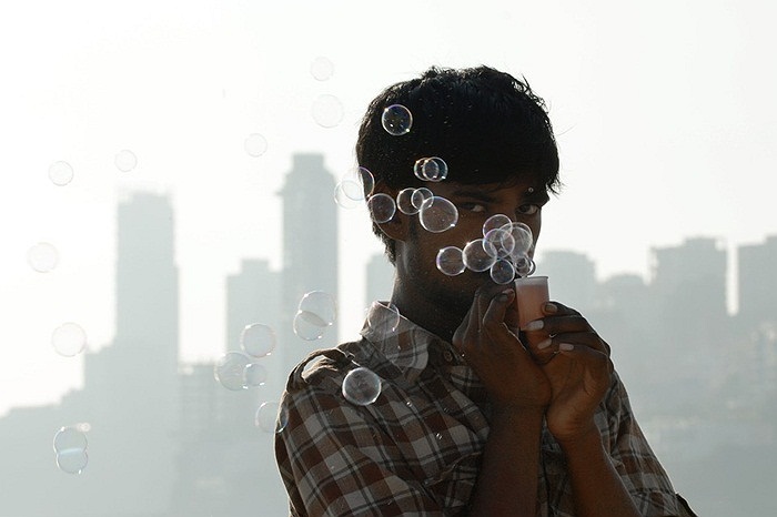 Cậu bé bán rong thổi bong bóng trên đường phố Mumbai, Ấn Độ
