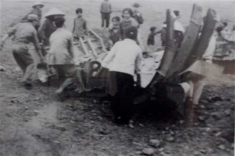 Dân quân tự vệ kéo xác máy bay B52 bị bắn rơi ở phố Trần Phú (Theo Dân trí)