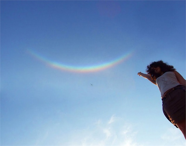 Một cô gái Mỹ thích thú tạo dáng với hình ảnh cầu vồng ngược - nụ cười lấp lánh của bầu trời hồi tháng 12 năm 2009.