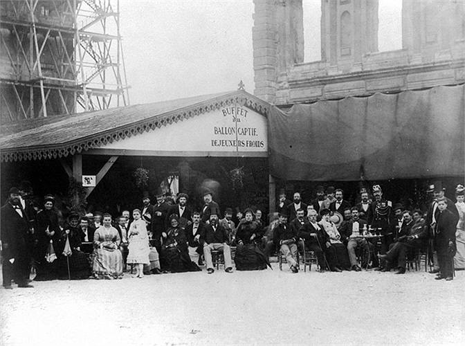 Những người chưa may mắn ngồi trong quán giải khát thưởng thức đồ uống và ngắm khinh khí cầu đang bay trên cao