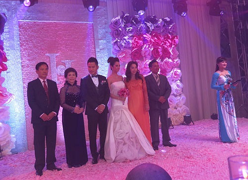 Bố mẹ hai bên cùng Đức Hải - Jennifer đứng lắng nghe tuyên bố của chủ hôn. Sân khấu và backdrop đều được gắn hoa hồng các cỡ, đồng nhất với cách trang trí tại lễ vu quy sáng nay tại nhà cô dâu. (Ảnh: VnE)