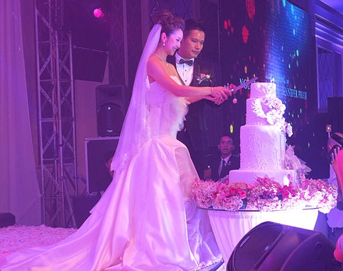 Đôi uyên ương chung tay cắt bánh cưới.