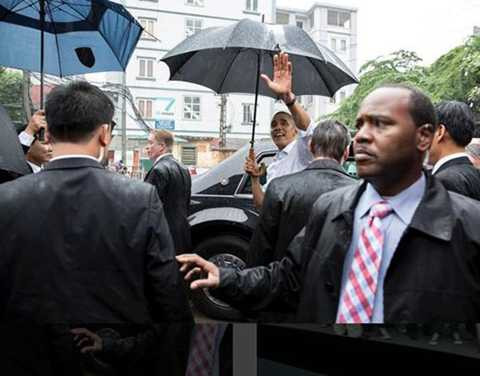 Tổng thống thứ 44 của Mỹ cầm ô và vẫy chào người dân Hà Nội trước khi lên xe ra sân bay Nội Bài để di chuyển vào TP HCM.