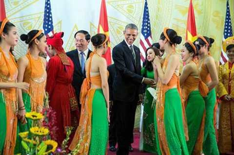 Ông Obama tươi cười, trò chuyện với thành viên đoàn ca múa nhạc khi dự tiệc do Chủ tịch nước Trần Đại Quang chủ trì tại Trung tâm Hội nghị Quốc gia ngày 23/5.