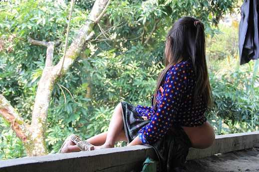 Trong lúc chúng tôi trò chuyện với bà Chủ, Lúa ngây ngô ngồi ở đầu hiên nhà, đôi mắt nhìn xa xăm xuống ngôi trường trung tâm bản. Từ bé cháu cũng chẳng được xuống đến ngôi trường vì không thể bò xuống được con dốc dựng đứng trước nhà. 