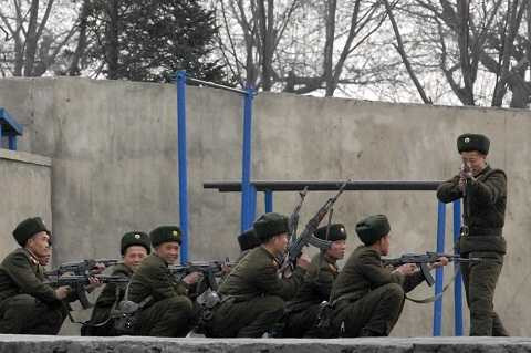 Một người lính Triều Tiên chĩa súng vào nhiếp ảnh gia khi đang luyện tập trên bờ sông Yalu, thị trấn Sinuiju.