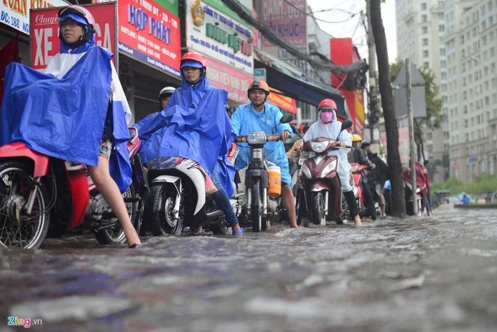 Do lòng đường ngập sâu nên người dân phải xếp hàng, nhích từng chút trên vỉa hè đường Nguyễn Hữu Cảnh. 