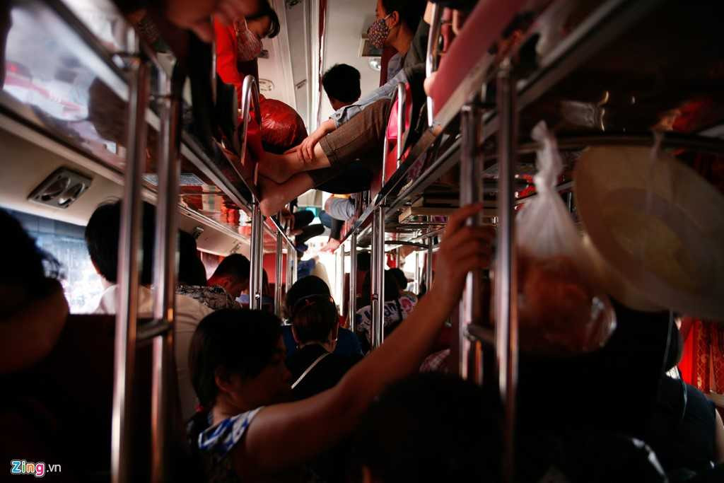 Bên trong một nhà xe chạy tuyến Giáp Bát - Sầm Sơn. Một em bé phải ngồi ở lối đi giữa hai hàng ghế vì hết chỗ.