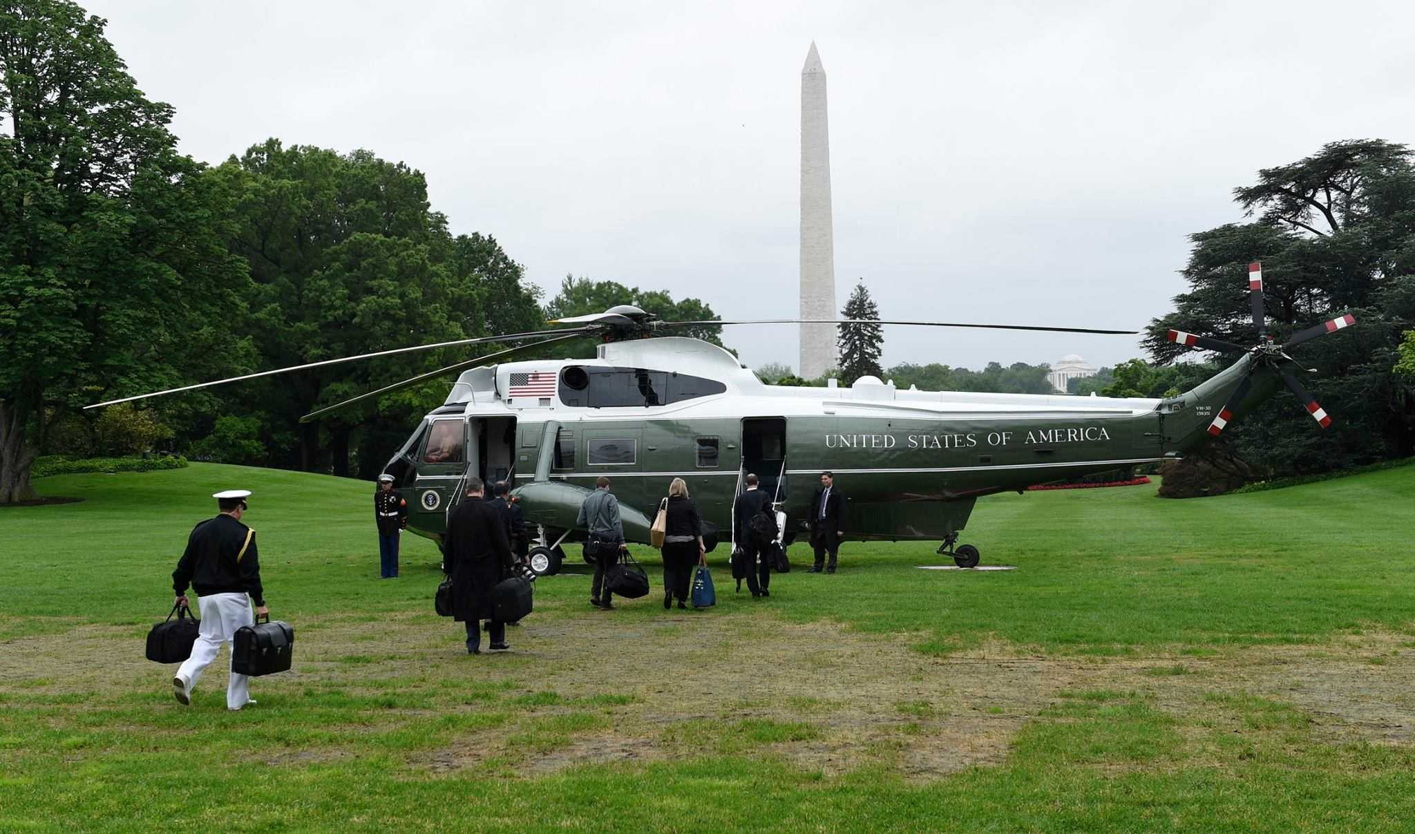 Các nhân viên cấp cao của Mỹ tháp tùng Tổng thống Obama đi ra chiếc máy bay lên thẳng Marine One